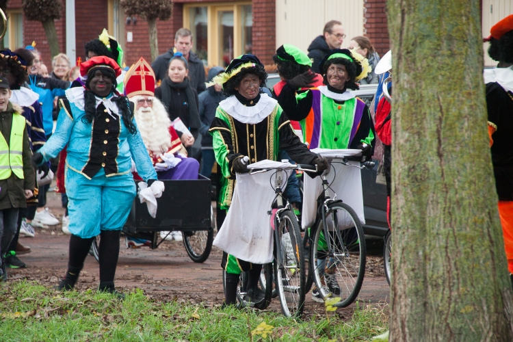 Zwarte Pieten op de step met de zak aan het stuur en Sinterklaas in een bakfiets